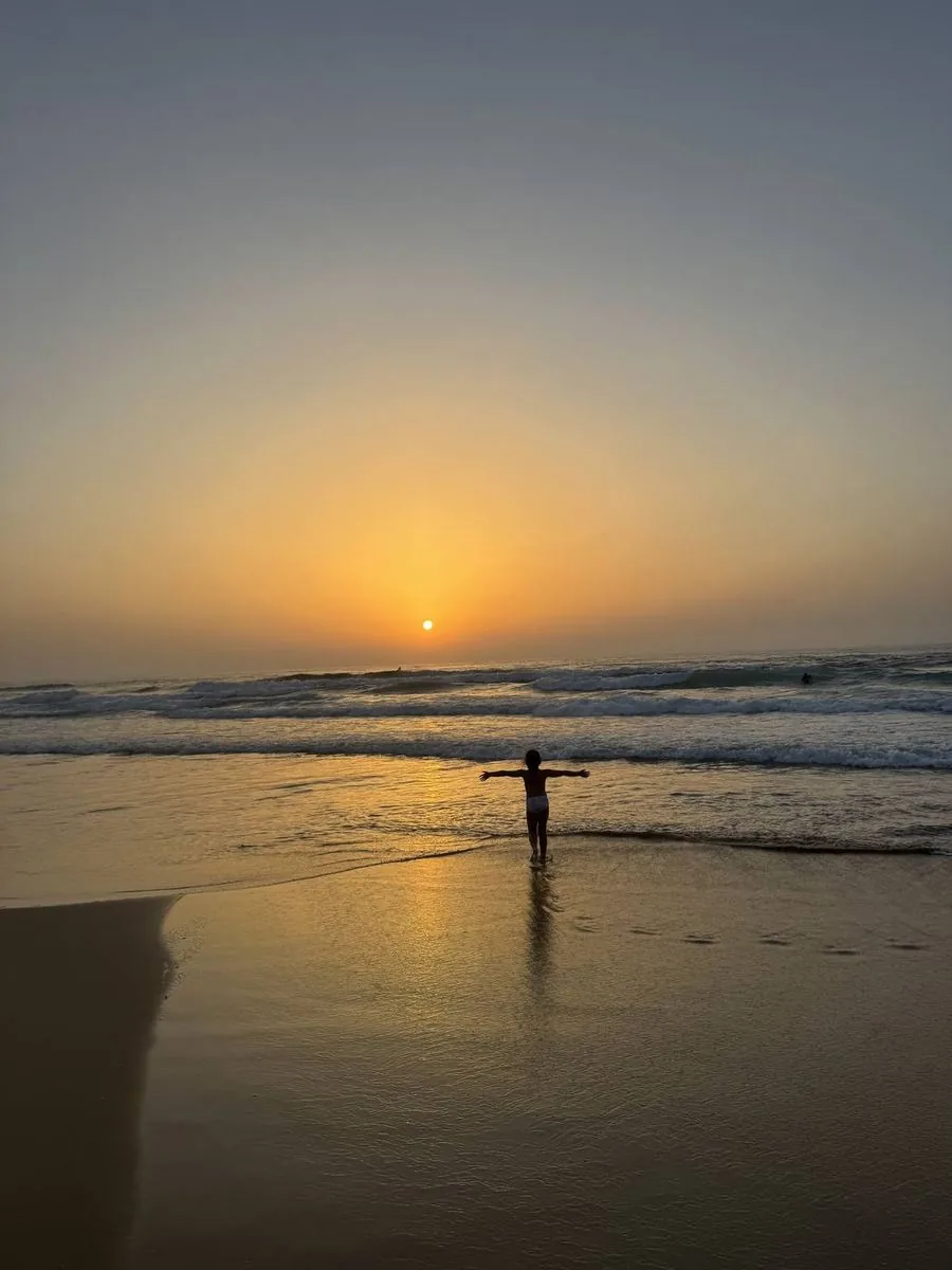 Child in the waves at sunset